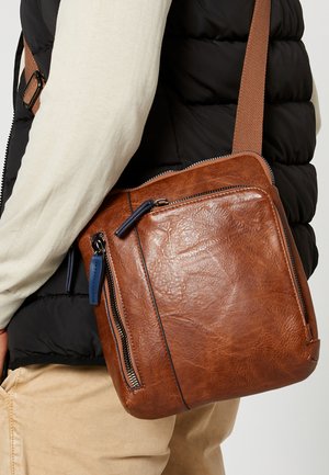 Brown leather messenger bag with multiple zippered pockets, textured finish, adjustable strap, and contrast blue zipper pulls.