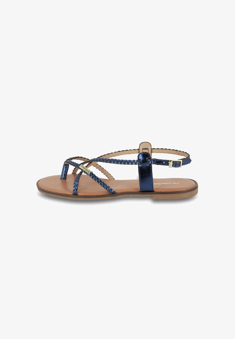 Marineblauwe sandalen met banden en geweven details, vlakke zool en verstelbare enkelriem. Gemaakt van glanzend materiaal met een soepele leren binnenzool.