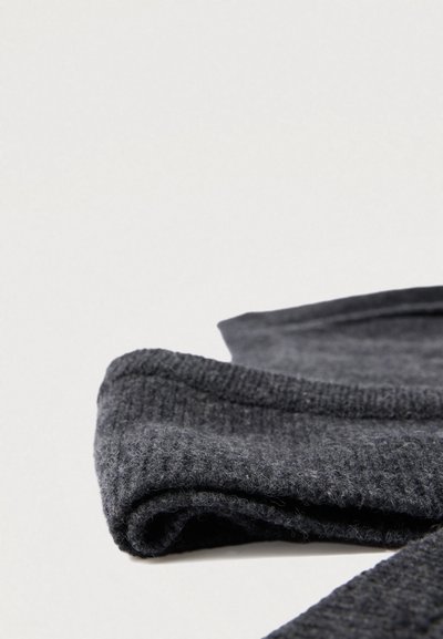 Tumehall kangas, millel on sooniline tekstuur ja siledad aktsendid, pehmete, karvaste kiududega pinnal.