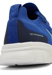 Μπλε αθλητικό παπούτσι με αναπνεύσιμο πλεκτό πάνω μέρος, σφιχτή κατασκευή και λευκή σπογγώδη σόλα. Διαθέτει υφασμάτινη πλάτη και λουράκι.