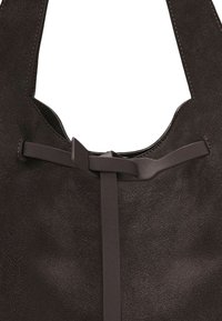 Borsa tote in camoscio marrone con parte superiore curva, manici piatti e un dettaglio decorativo a fiocco sul davanti. Tessuto morbido con leggero effetto lucido.