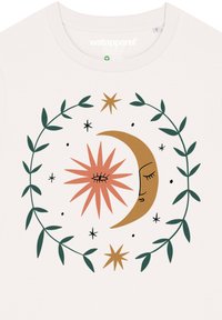 Korte mouw crèmekleurig t-shirt met een cirkelontwerp met een gouden halve maan, roze ster, groene bladeren en zwarte accenten.