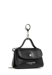 Piccolo portachiavi in pelle nera Lancaster Paris con dettagli in catena e chiusura argento su sfondo bianco.