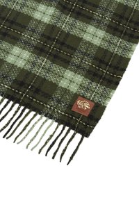 Sciarpa in plaid di lana nei colori verde scuro, verde chiaro e nero. Presenta bordi frangiati e un'etichetta in pelle marrone con un logo di leone.