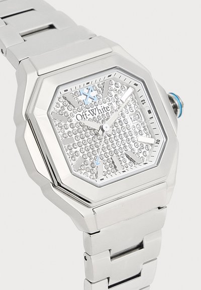 Montre-bracelet en métal argenté avec cadran hexagonal, cadran incrusté de cristaux, marque Off-White et aiguilles ainsi que détail de la couronne accentués de bleu clair.