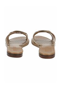 Sandali piatti in tan con due sottili cinghie, punta arrotondata e dettagli della suola forati. La suola presenta una leggera elevazione e accenti marroni scuri.