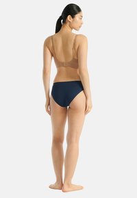 Brązowy biustonosz z regulowanymi ramiączkami, zestawiony z granatowymi figami bikini. Gładka faktura, prosty design i klasyczny krój obu elementów.