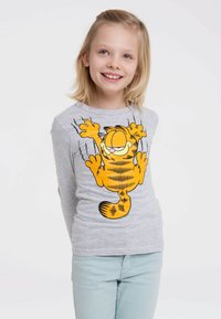 Graues Longsleeve-Shirt mit einem leuchtend orangefarbenen Garfield-Graphic und schwarzen Linien. Das Shirt hat einen runden Ausschnitt und eine taillierte Passform.