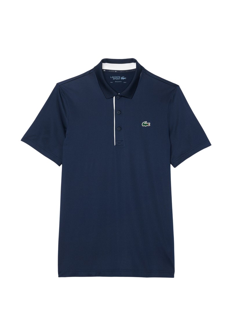 Polo di colore blu navy realizzato in tessuto liscio, con colletto bianco a contrasto, chiusura con tre bottoni e piccolo logo di un coccodrillo verde sul petto.