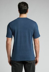 Námořnická modrá krátký rukáv tričko, kulatý výstřih, strukturovaná tkanina, volný střih a rovný lem. Viditelné švy a mírný melírovaný vzor.