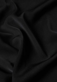 Tissu noir drapé en plis, texture lisse, avec un léger éclat réfléchissant la lumière, sans motifs ni accents visibles.