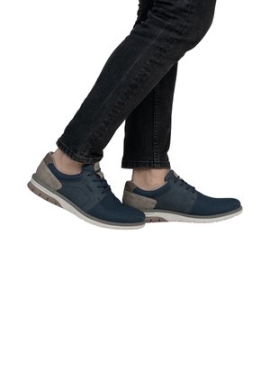 Baskets bleuies avec une tige texturée et des accents gris. Les caractéristiques incluent une semelle rembourrée et un design à lacets. Ensemble porté avec un jean foncé.