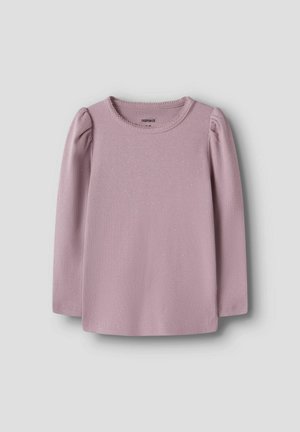 Haut côtelé rose poudré à manches longues, avec des épaules froncées et une encolure ronde, sur un fond uni gris clair.