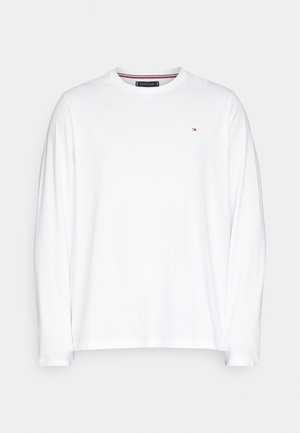 Bílá dlouhá bavlněná tričko s dlouhým rukávem, s kulatým výstřihem a malým barevným logem na levé části hrudníku. Měkká textura.