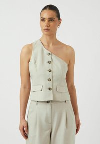 Lichtgrijze linnen top met één schouder en zes knoopsluitingen, zijzakken, op maat gemaakt ontwerp, gladde textuur. Vergezeld van bijpassende broek.
