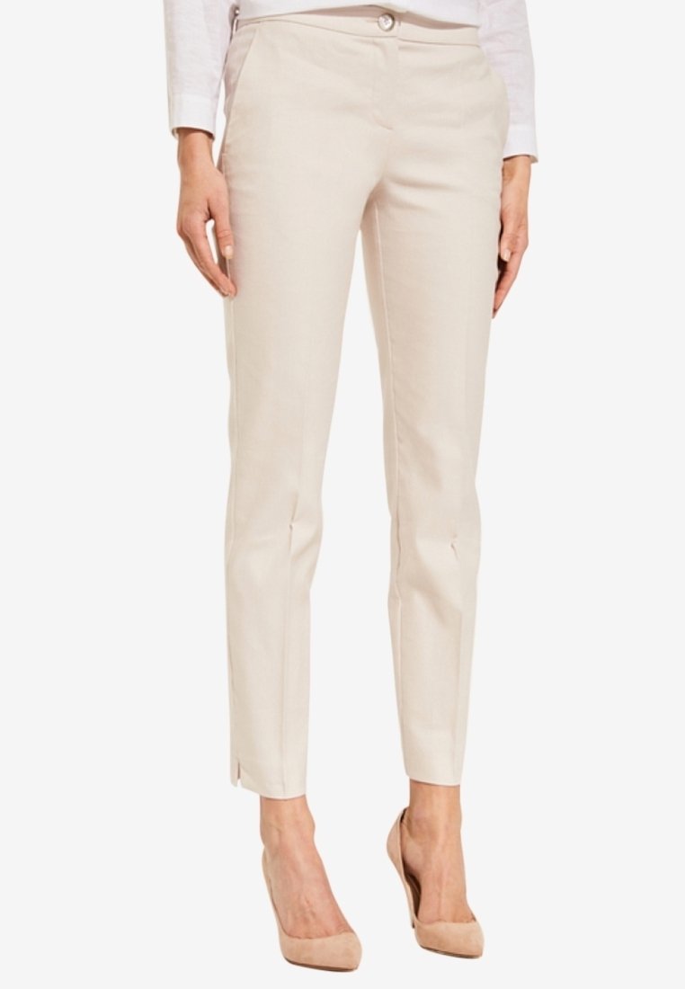 Beige maßgeschneiderte Hosen mit schmaler Passform, aus einem glatten Stoff gefertigt, mit Fronttaschen und leichten Schlitzen am Knöchel.