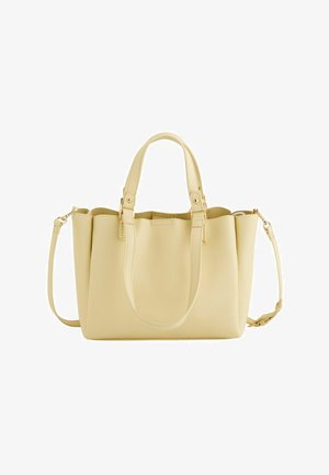 Sac fourre-tout en cuir beige avec deux poignées et une bandoulière amovible, doté d'une fermeture éclair et de détails métalliques minimalistes.