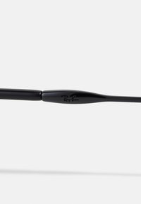Mustad musta Ray-Ban'i prillid on varustatud seda luksuslikku plastist raamiga, millel on sile ja läikiv pind ning eristuv logo prossi peal.