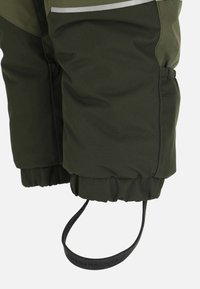 Groene waterdichte broek met elastische manchetten, reflecterende streep en zwarte verstelbare band met het label "SWEDEMOUNT." Zacht, gestructureerd materiaal.