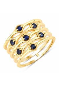 Goldring mit vier Bändern, die ein wellenförmiges Design aufweisen. Besetzt mit fünf runden, navyblauen Steinen und mit einer glatten und polierten Oberfläche.