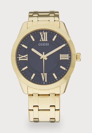 Montre dorée avec un cadran bleu, des chiffres romains et un bracelet en métal. Ses caractéristiques comprennent un boîtier rond, deux aiguilles et une finition polie.