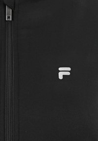 Giacca nera con zip, dal tessuto liscio e logo F bianco. Presenta una chiusura frontale con zip e vestibilità aderente. Nessun ulteriore motivo o dettaglio.