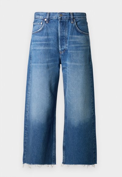 Jeans de mezclilla anchos de color azul claro con un dobladillo deshilachado, diseñados con cinco bolsillos y un cierre de botón en la cintura.