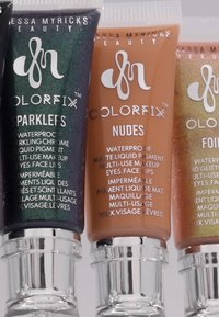 Tre rør med flytende pigment: svartgrønn med glitter, matt nude og skinnende brun med sølvhette, merket Colorfix.