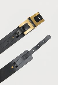 Μαύρη δερμάτινη ζώνη με αγκράφα από μέταλλο σε χρυσό τόνο, με ορθογώνιο σχέδιο, λεία υφή και πολλαπλές τρύπες ρύθμισης.