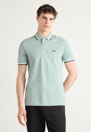 Ljusgrön polotröja med krage, med en svart och vit randig accent och en broderad "BOSS"-logotyp på vänster bröst.