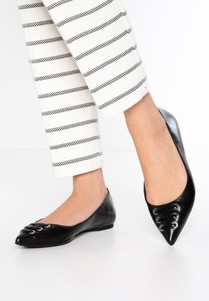Schwarze Ballerinas aus Leder mit spitzer Kappe, die dekorative Ösen-Schnürung am Obermaterial aufweisen. Glatte Textur, flache Sohle.