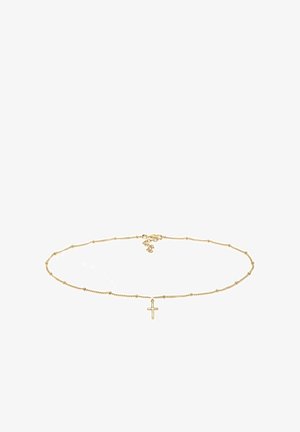 Collier en chaîne d'or délicat avec de petites perles espacées régulièrement et un petit pendentif croix en or au centre, posé à plat sur un fond blanc.