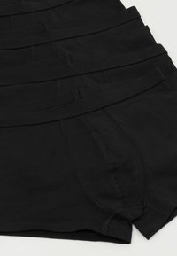 Schwarze Baumwollboxershorts mit elastischem Bund, die eine glatte Textur und flache Nähte aufweisen. Sauber in einem Stapel angeordnet.