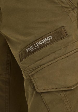 Pantalones cargo verde olivo con un parche de tela que dice "PME LEGEND AMERICAN CLASSIC," que cuentan con múltiples bolsillos y una textura suave.