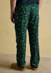 Zaļās pidžamas bikses ir ar atkārtotu rakstu, kas attēlo dažādus rotaļīgus figūriņas spilgtās krāsās. Elastīgs jostasvīrs un mīksta auduma.