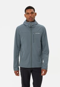 Veste softshell grise avec capuche, fermeture éclair frontale et deux poches latérales zippées. Présente un logo sur la partie gauche de la poitrine. Texture lisse.