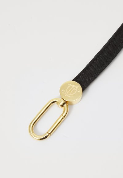 Sangle en tissu noir avec un fermoir rond en métal doré arborant un logo en relief et un clip carabine en métal doré.