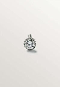 Pendiente de botón redondo con una piedra preciosa clara, engastada en un metal de tono plateado, con un sencillo ajuste de garras y un acabado pulido.
