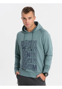 Sudadera con capucha en color azul verdoso, que presenta un llamativo estampado en azul con la palabra "DENIM" en el frente, con mangas raglán y capucha ajustable.