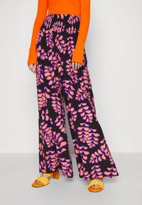 Pantalons larges noirs présentant un motif de feuilles vibrantes orange et violet, en tissu léger avec une taille élastique.
