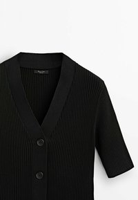 Schwarze gerippte Strickjacke mit kurzen Ärmeln, V-Ausschnitt und zwei vorderen Knöpfen. Sie verfügt über eine glatte Textur und eine moderne, strukturierte Form.
