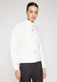 Baltas pūkinis džemperis su aukštu apykakle, priekyje užtrauktuku ir siuvinėtu tekstūru. Ilgos rankovės su elastinėmis apykaklėmis ir minimalistišku dizainu.