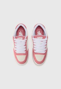 Vans sneakers featuring a pink suede upper, white laces, and cream toe cap. Includes a red insole with logo and textured rubber sole.