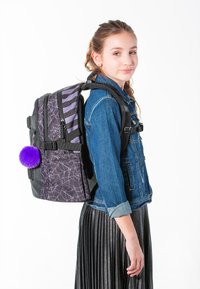 Zaino viola e nero con motivi a ragnatela, design a righe e un accento pom-pom peloso. Materiale robusto con spallacci regolabili.