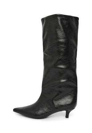 Bottine noire à bout pointu avec une texture cuir lisse et élégante, un talon slim et bas, et un design ample qui couvre le mollet.