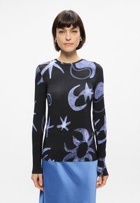 Μακρυμάνικη μπλούζα από μαύρο ύφασμα, με αφηρημένα απαλά μπλε σχέδια σε φεγγάρια και αστέρια; απαλή υφή με στρογγυλή λαιμόκοψη.