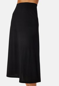 Musta midihame, joka on valmistettu pehmeästä ja joustavasta kankaasta. Siinä on leveä vyötärö ja A-linjainen muoto, joka tarjoaa mukavan istuvuuden ja liikkuvuuden.