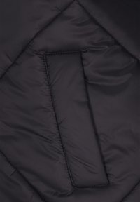 Material negru matlasat cu cusături diagonale și o secțiune dreptunghiulară căptușită în centrul său.