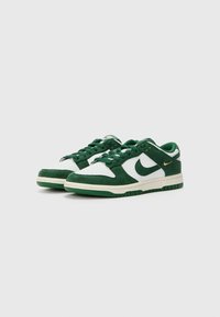 Grønne og hvide ruskind sneakers har en perforeret tå, polstret krave og en struktureret gummisål med guldfarvede detaljer.