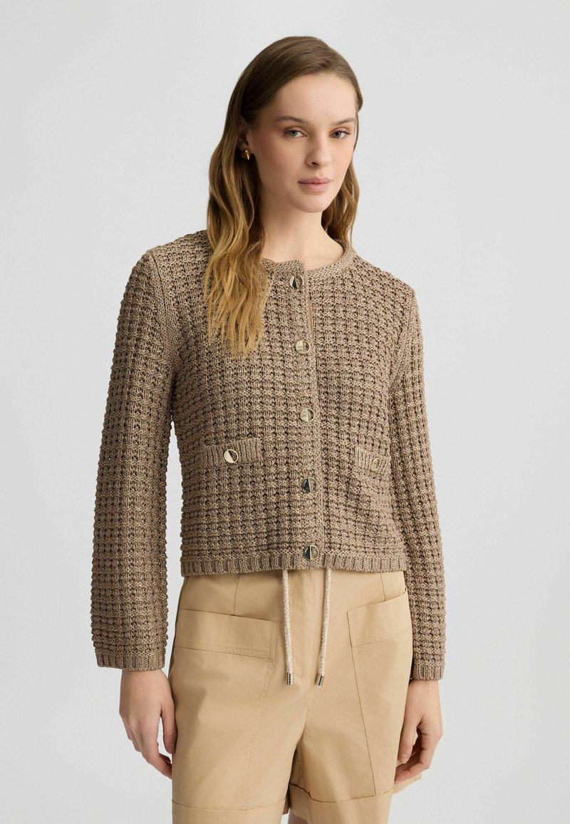 Cardigan lavorato a maglia beige con un motivo testurizzato, scollo rotondo, chiusura con bottoni, due tasche applicate e coulisse regolabile all'orlo.